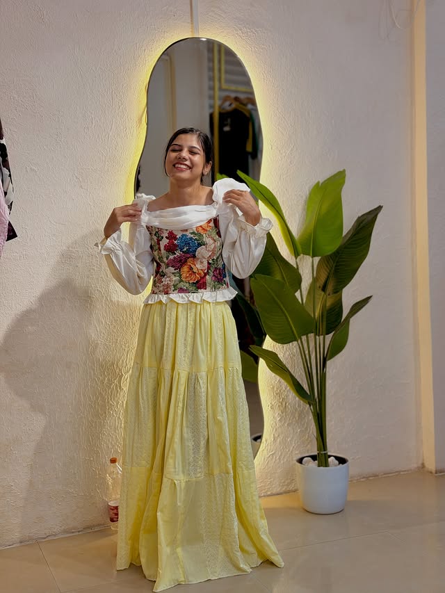 Model wearing a floral yellow dress at Rozzo